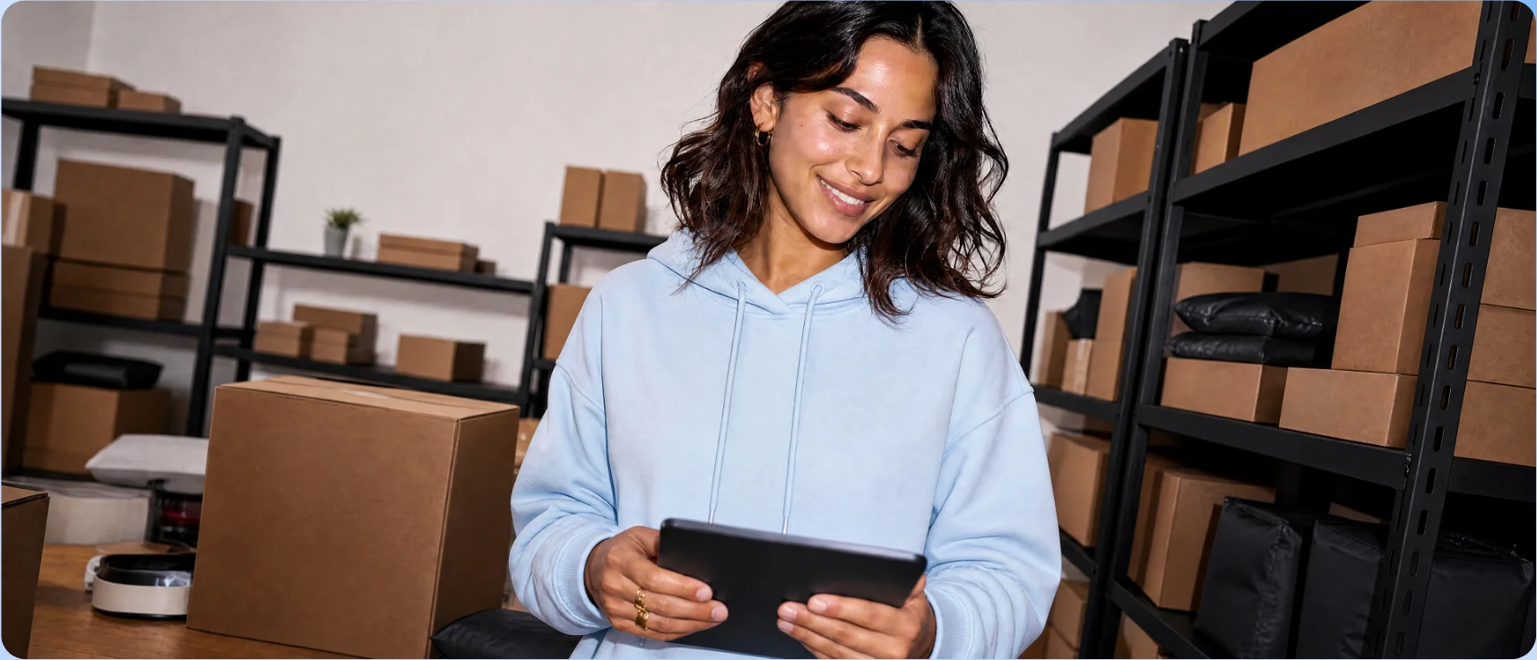 Warehouse worker holding a tablet while checking inventory Warehouse worker holding a tablet while checking inventory