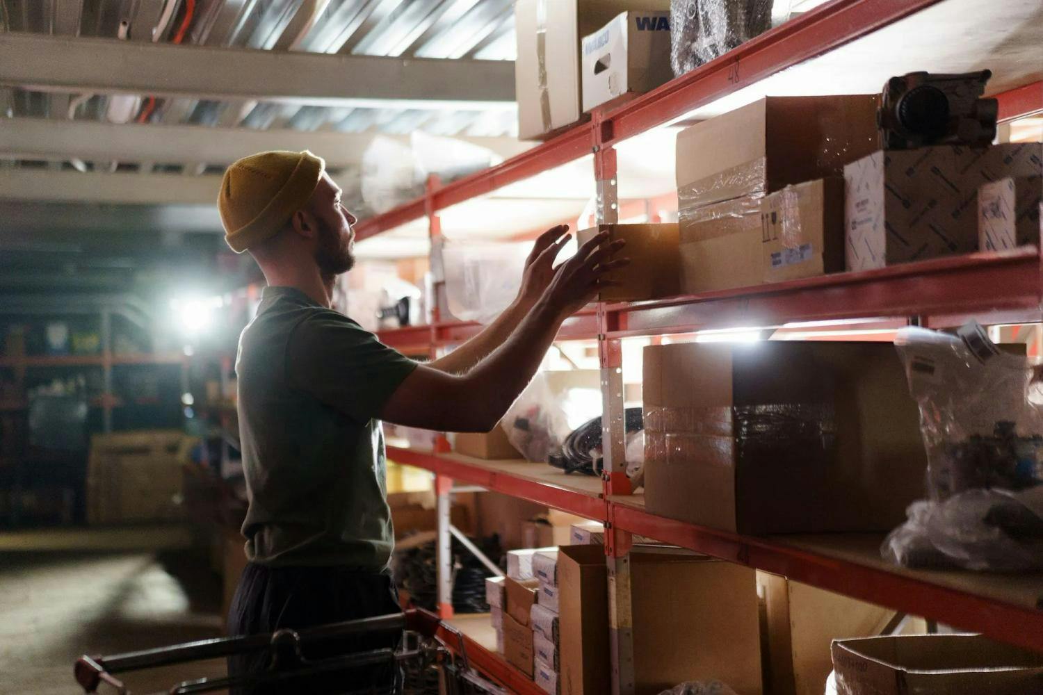 Man placing box on shelf in warehouse