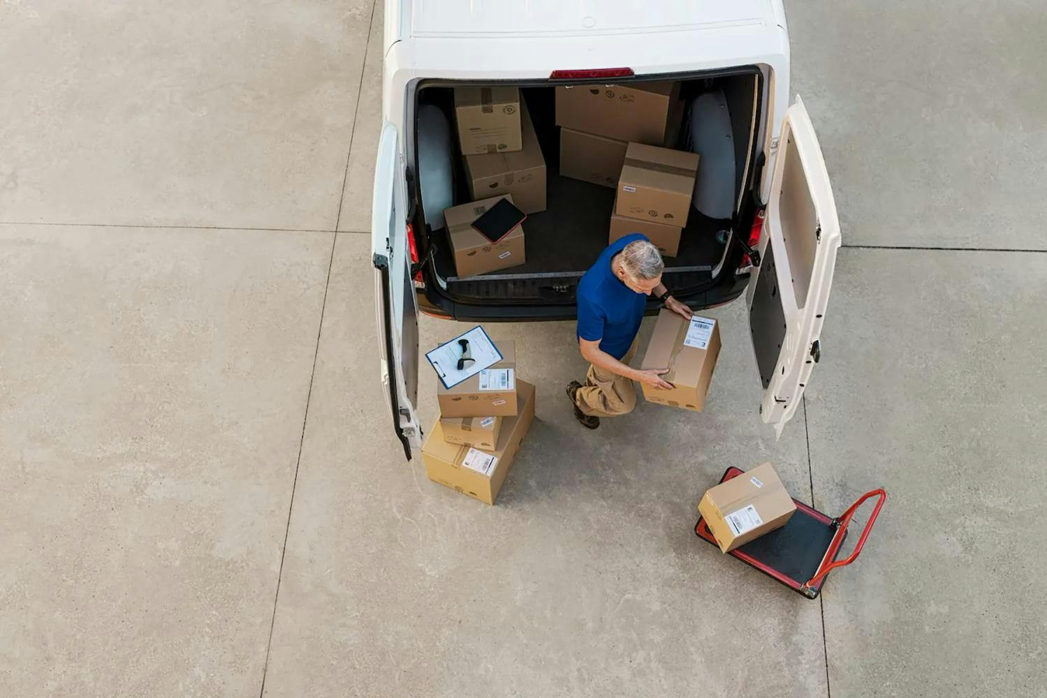 Courier unpacking parcels from delivery van