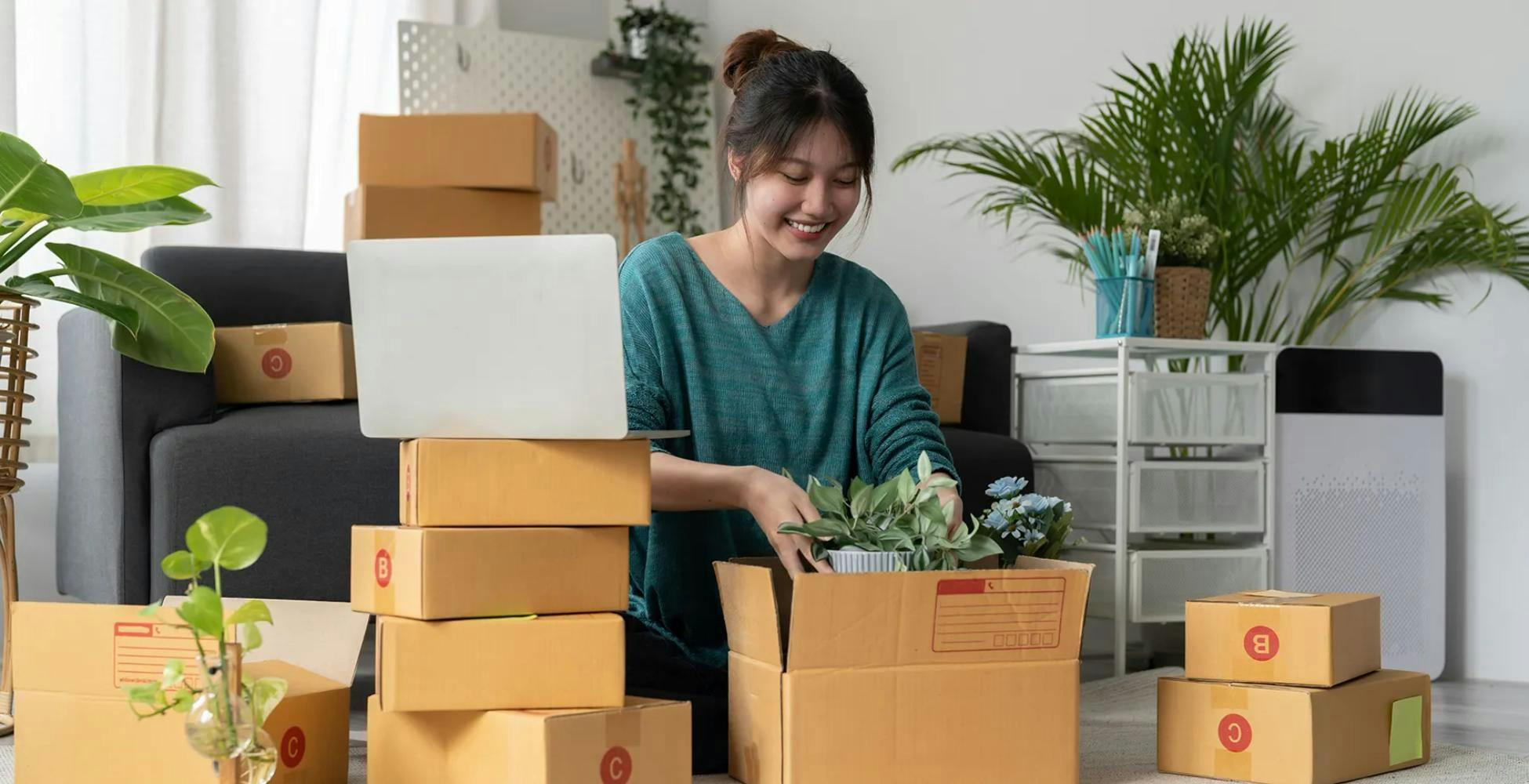 Small business owner packing small plants for shipping